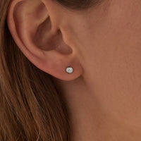 14K White Gold .05 CTW Natural Diamond Micro Bezel-Set Earrings worn by a model